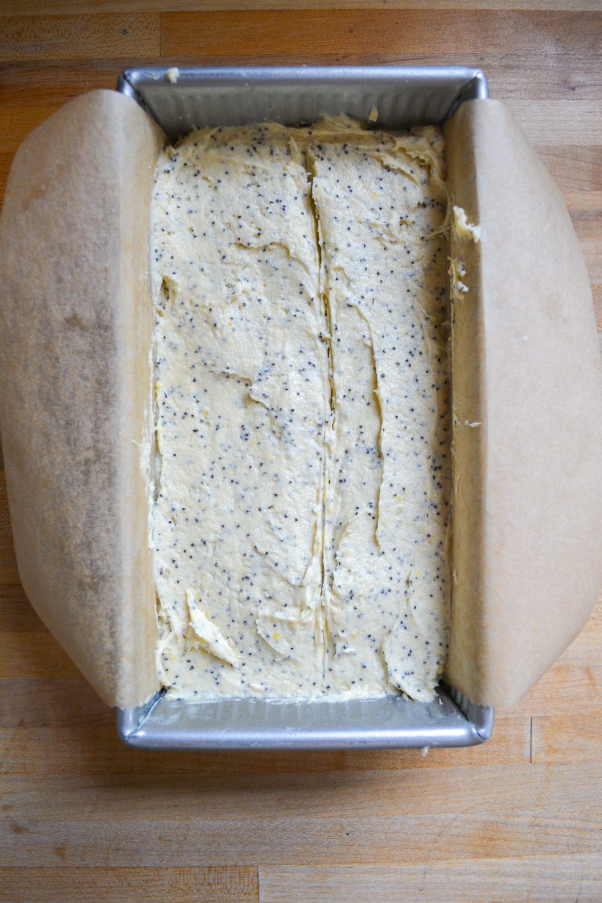 Unbaked Vegan Lemon Poppy Seed Pound Cake in a loaf pan.