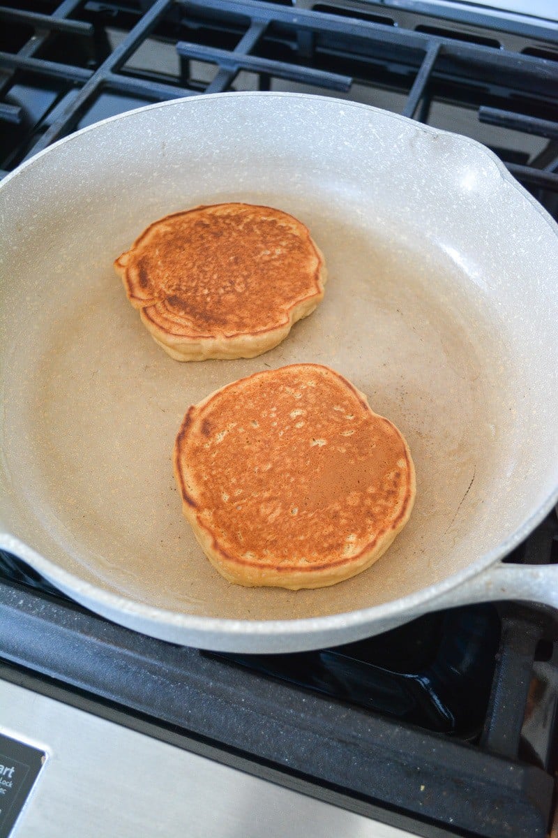 Two pancakes after being flipped on a skillet