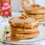 Portrait of two stacks of pancakes with cookie butter dripping down the side of the stack