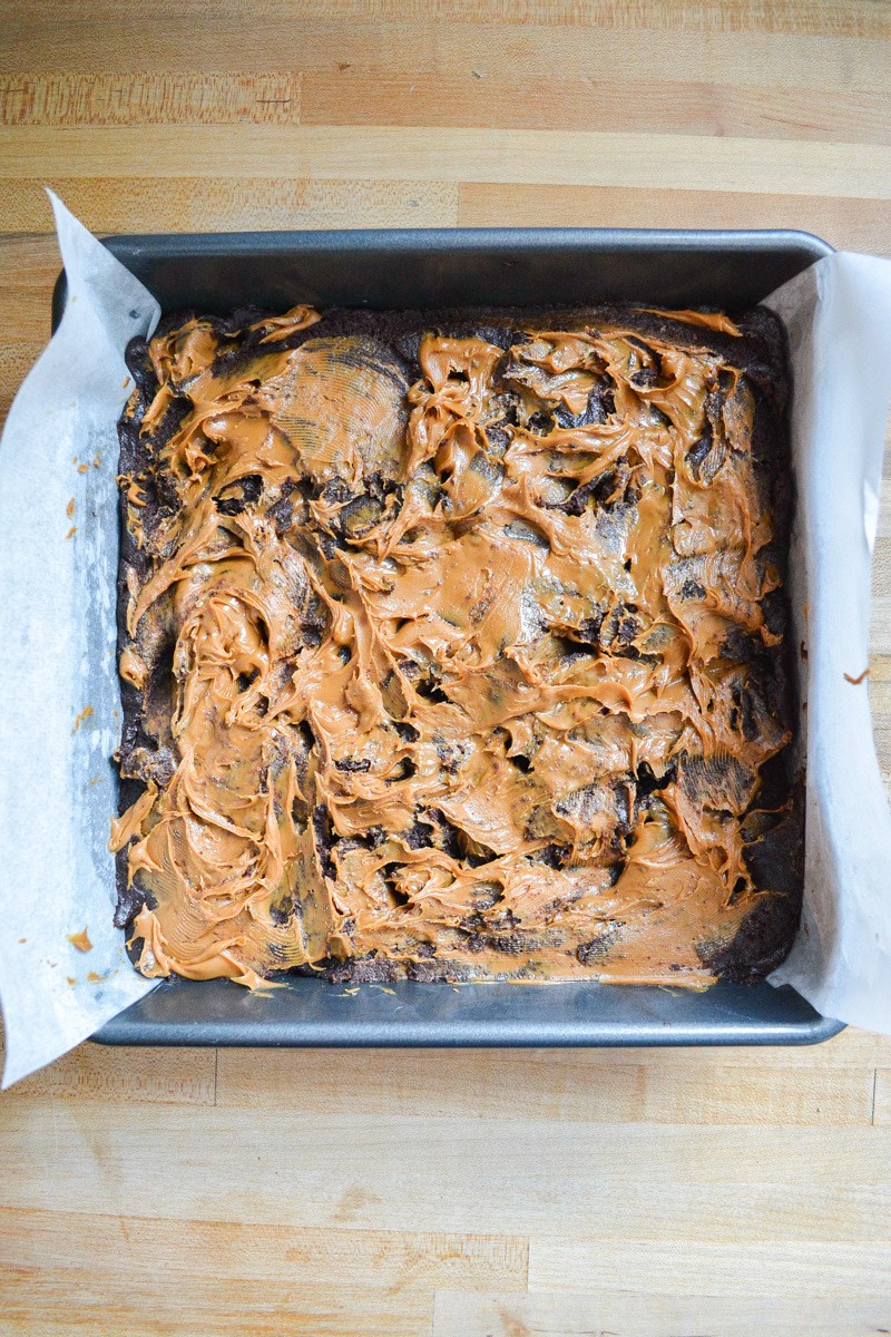 brownie swirled with cookie butter batter in a pan