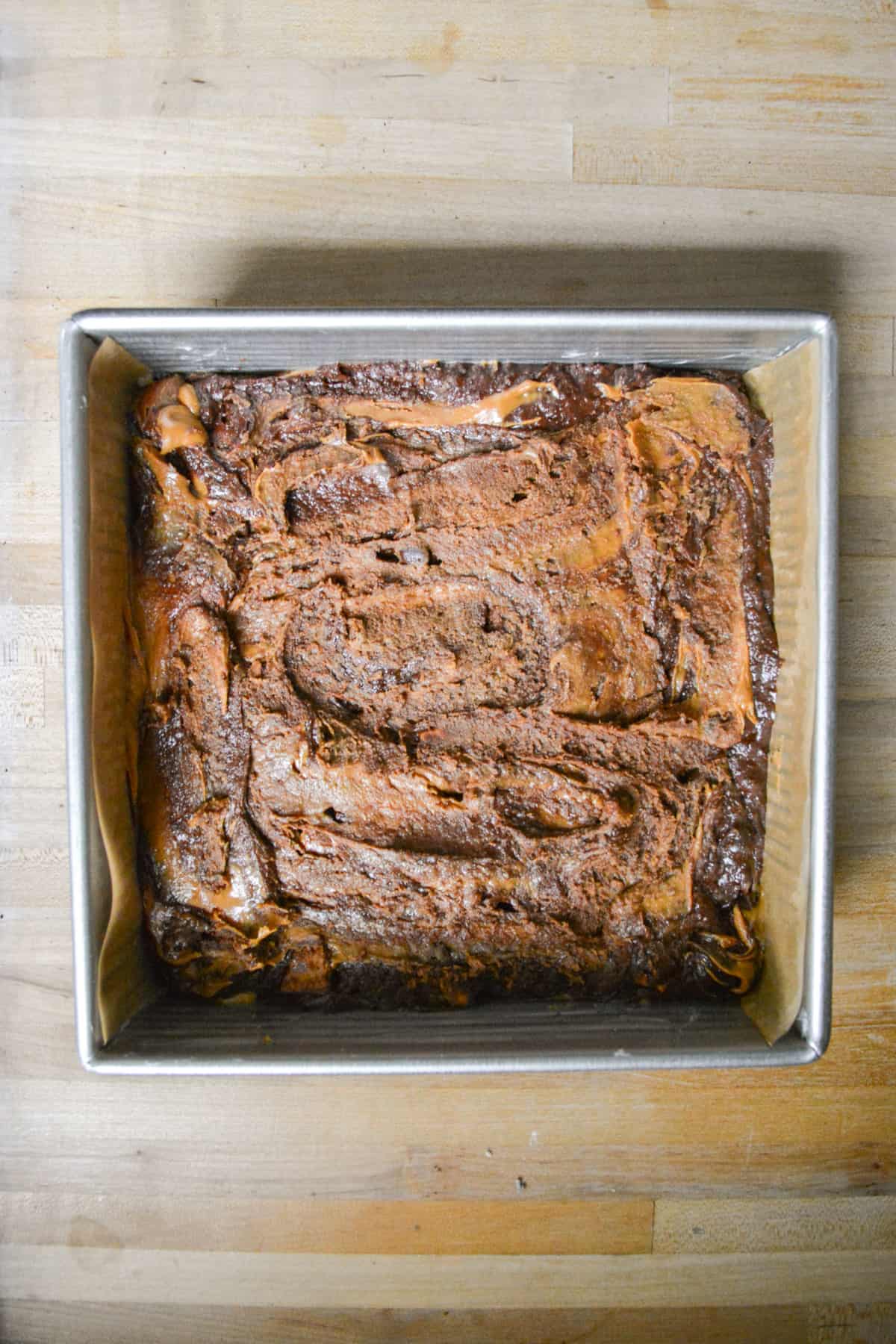 Cookie butter swirled into the brownie batter in a square baking pan.