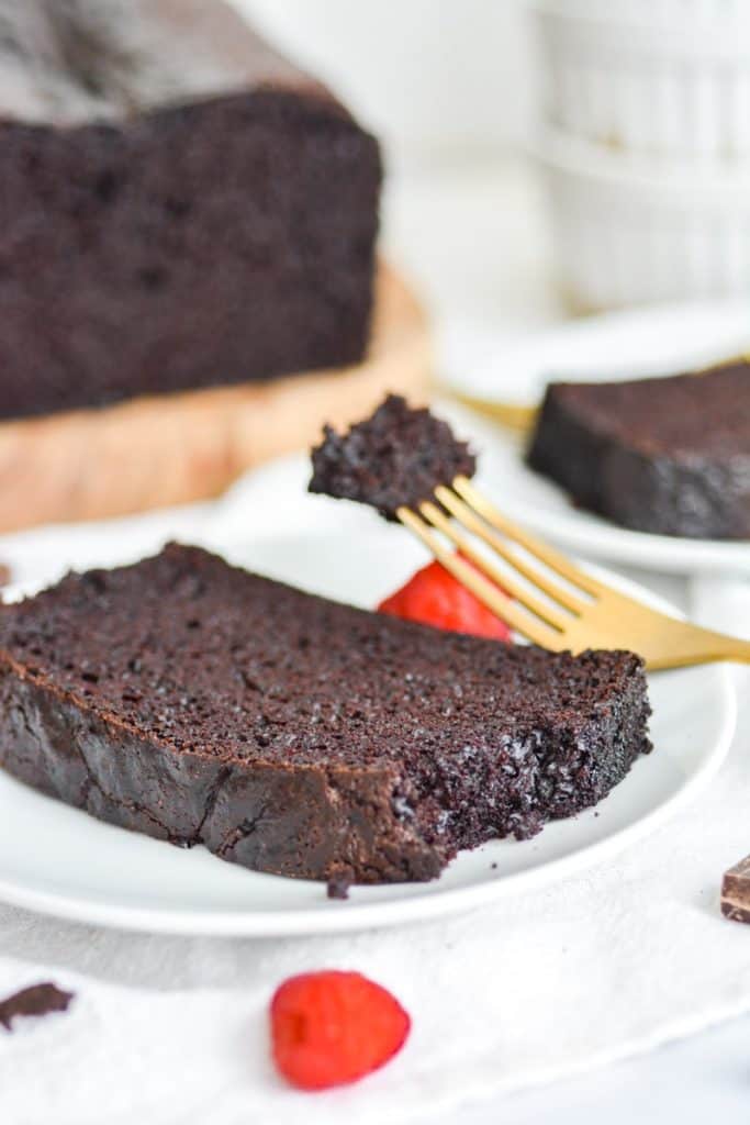 dairy free and eggless chocolate loaf cake on a plate with a bite taken out of it