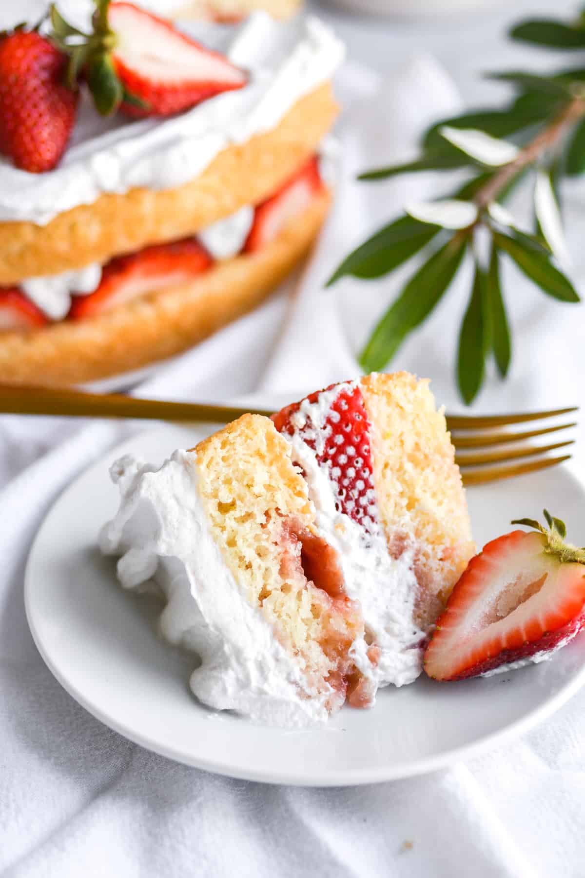 A slice of Vegan Strawberry Shortcake Cake on a white plate