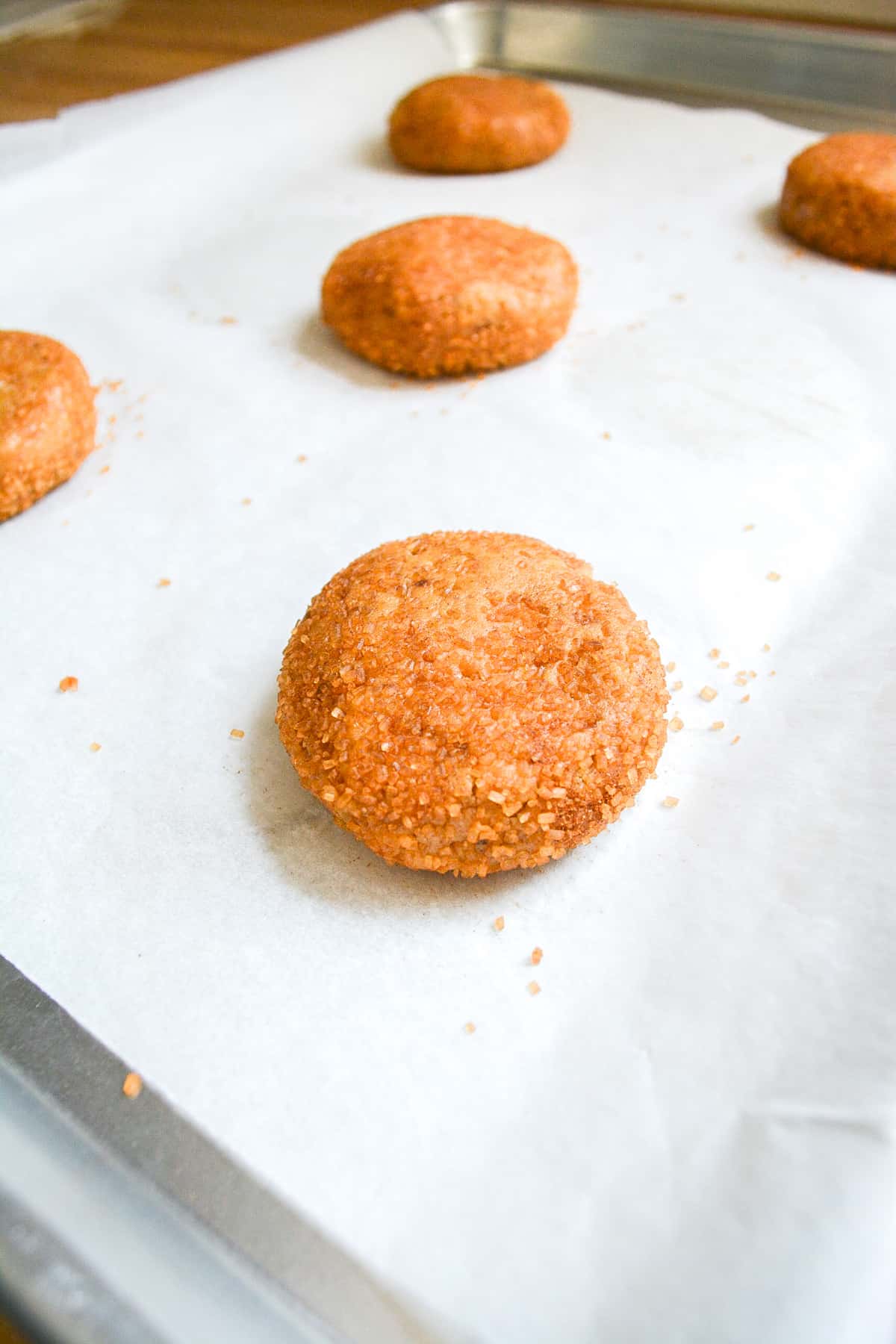 A cookie dough ball on a baking sheet