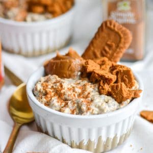 A ramekin filled with Biscoff overnight oats with cookie butter and biscoff cookis on top