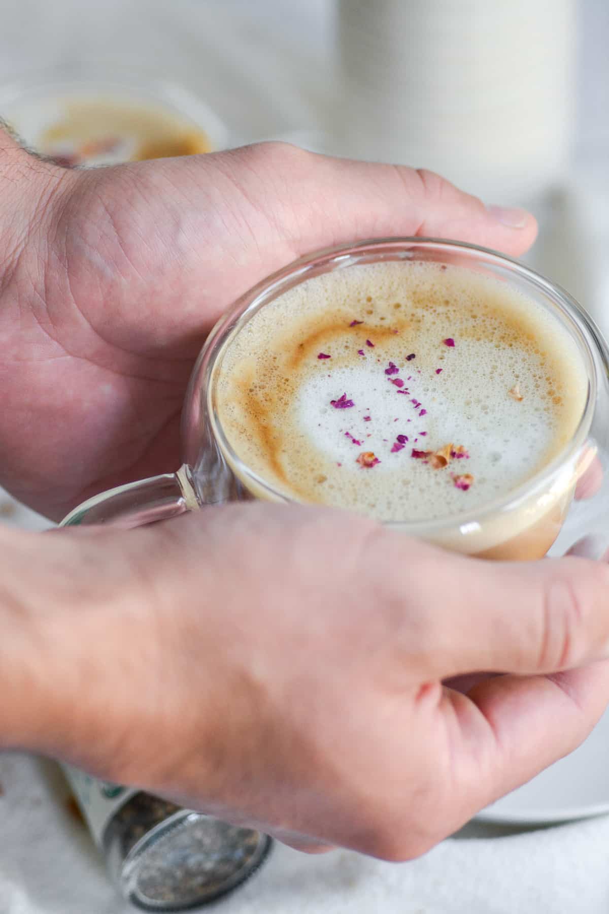 Hands holding a cardamom latte