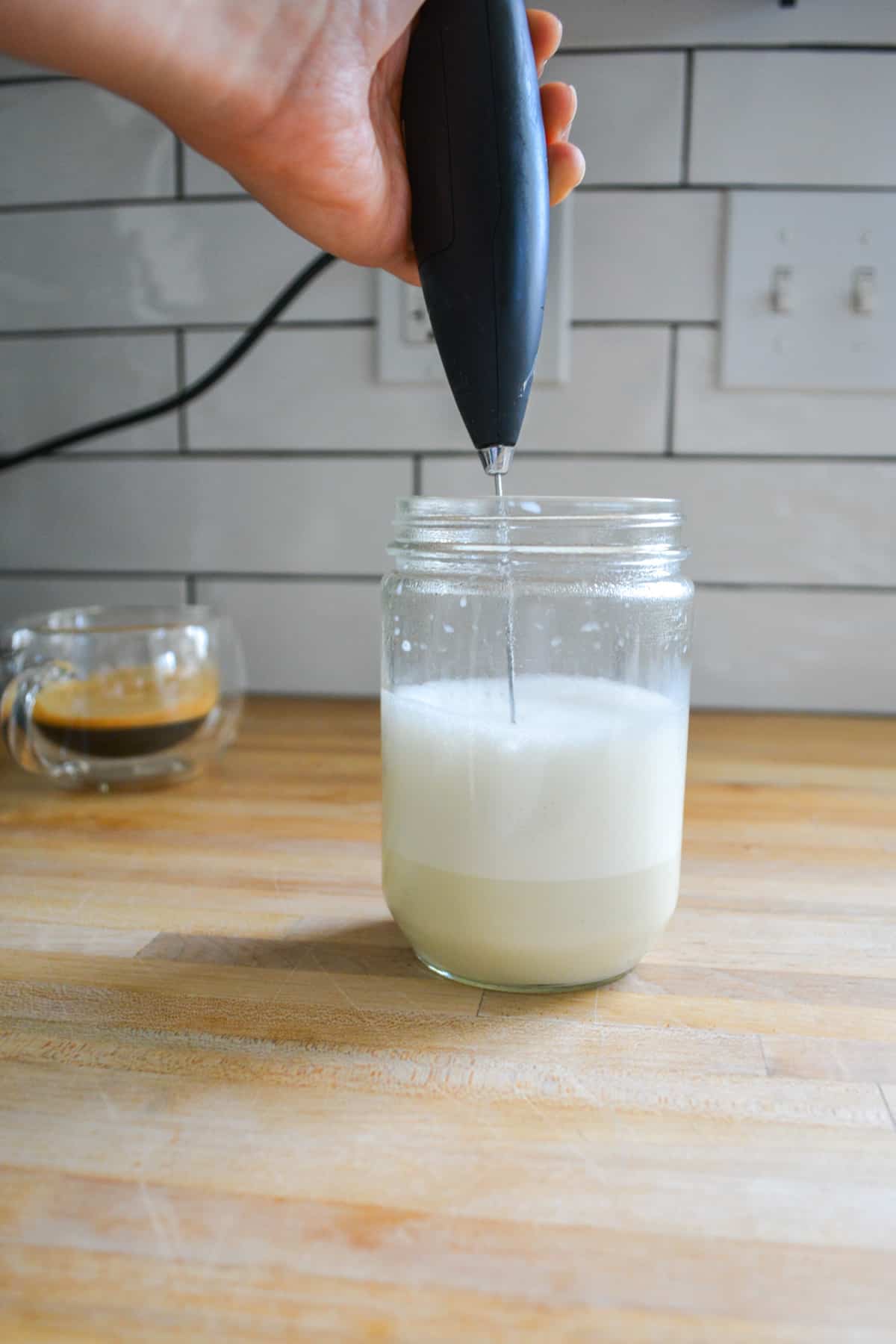 Frothing milk with a hand frother.