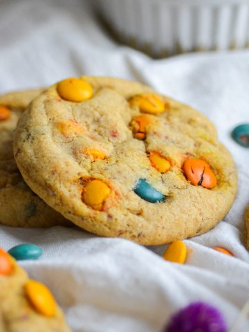 vegan cookies on a white cloth with vegan m&ms scattered arount