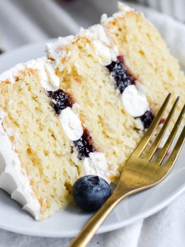 A slice of blueberry jam cake on a white plate