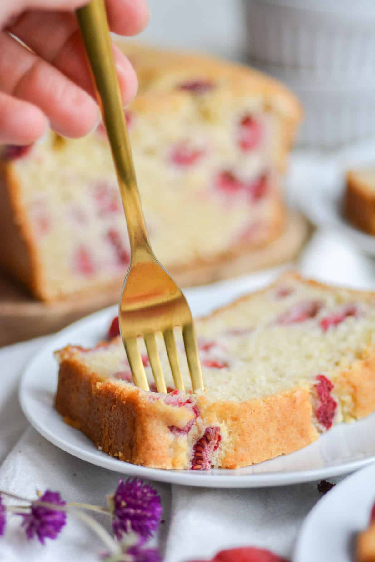 Gold fork in a slice of Vegan raspberry lemon cake