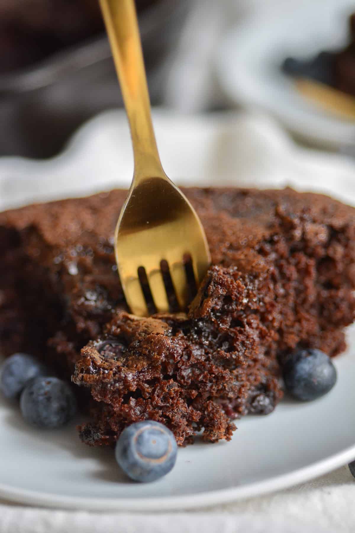 Fork in a piece of vegan chocolate blueberry cake