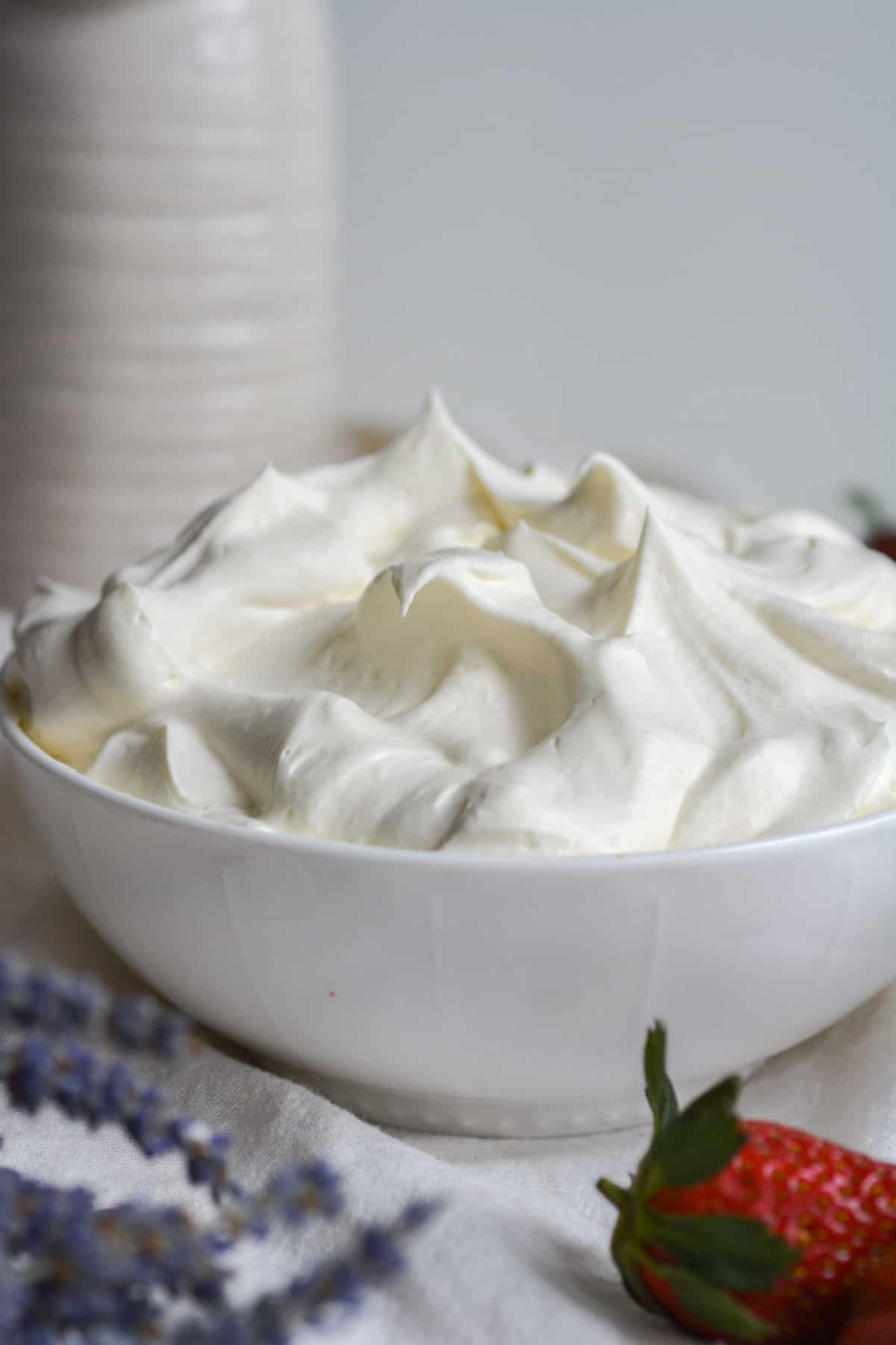 White bowl of vegan whipped cream frosting in a bowl