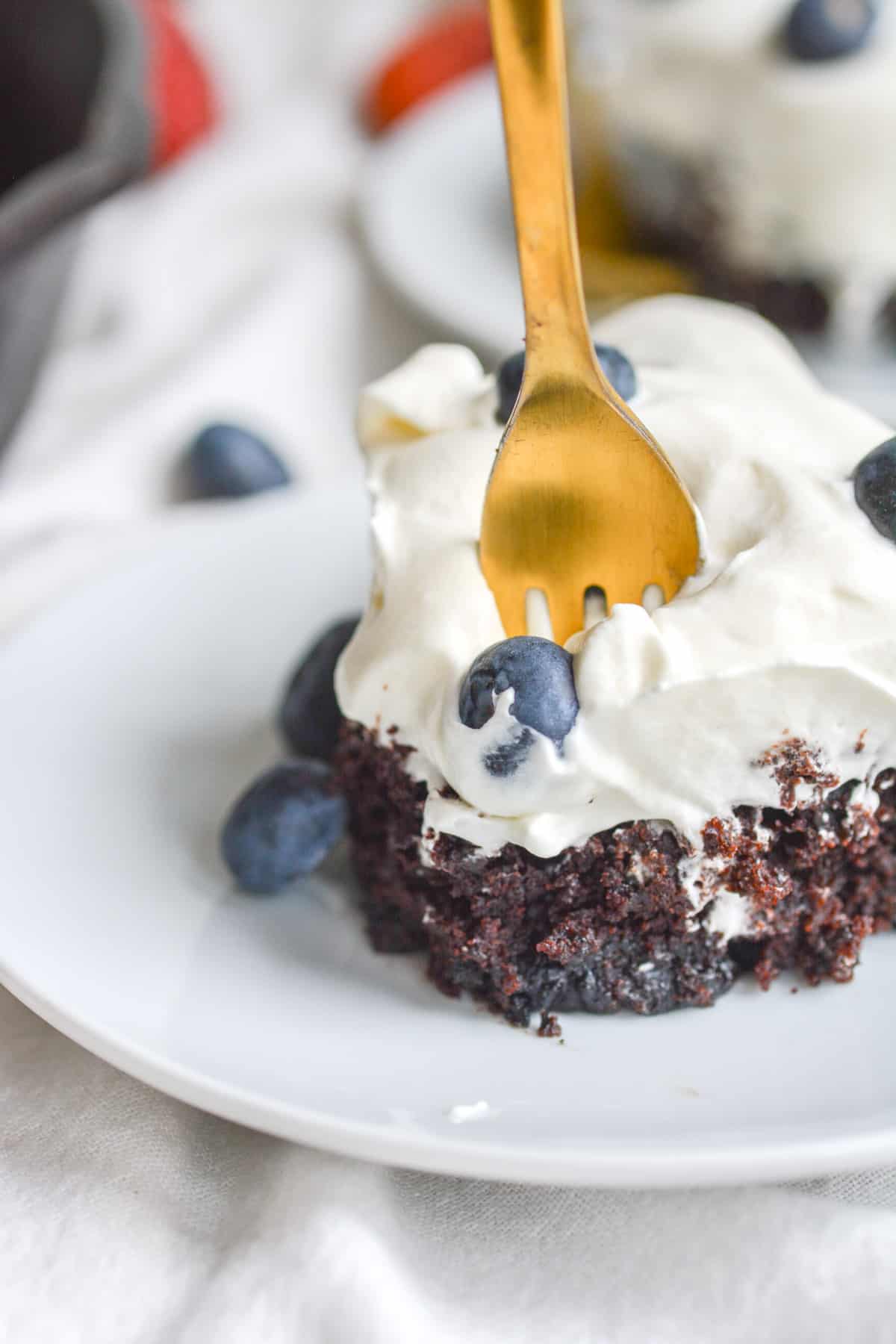 A fork in a vegan chocolate blueberry cake.