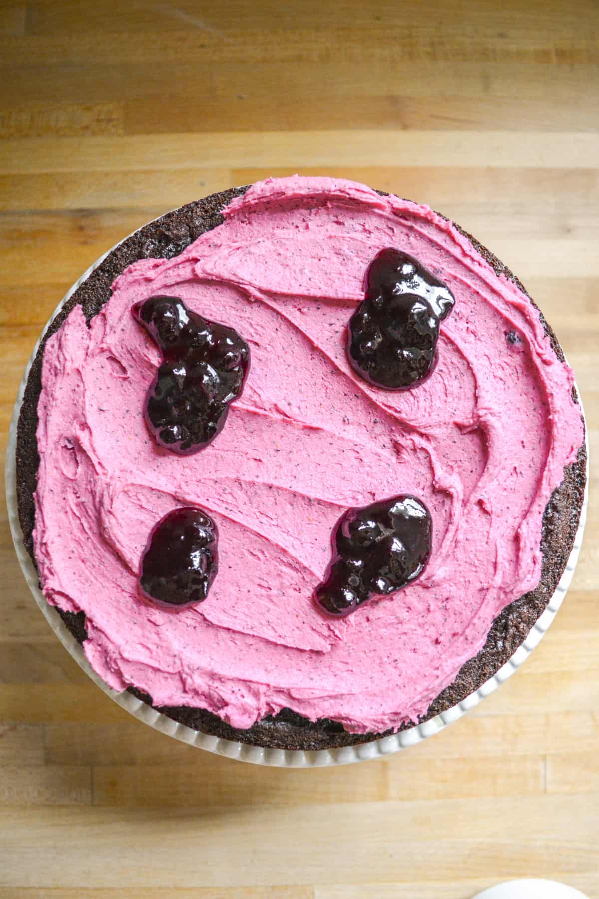 Chocolate cake topped with blueberry frosting and blueberry jam.