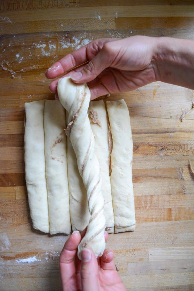 hand holding a twisted strip of dough