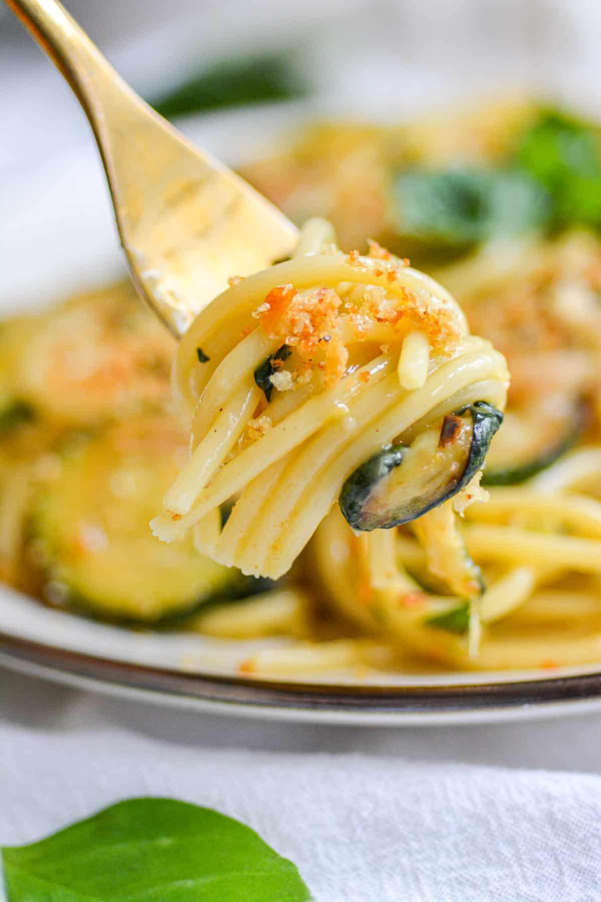 A fork with a bite of vegan zucchini pasta on it