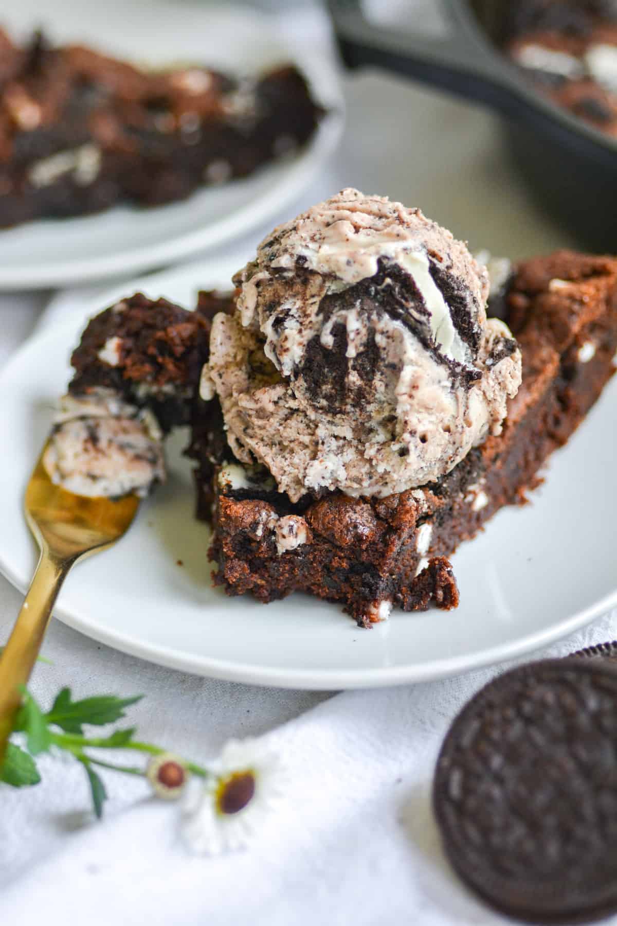 Vegan cookies and cream pizookie on a white plate with a bite taken out of it