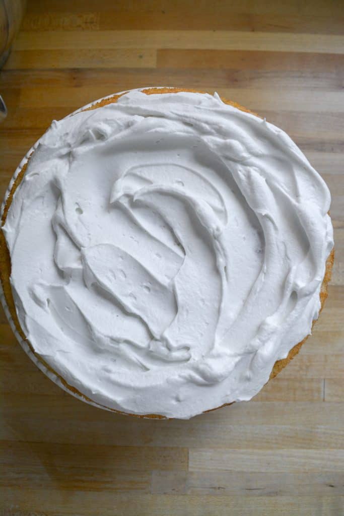 Whipped cream spread onto a cake layer