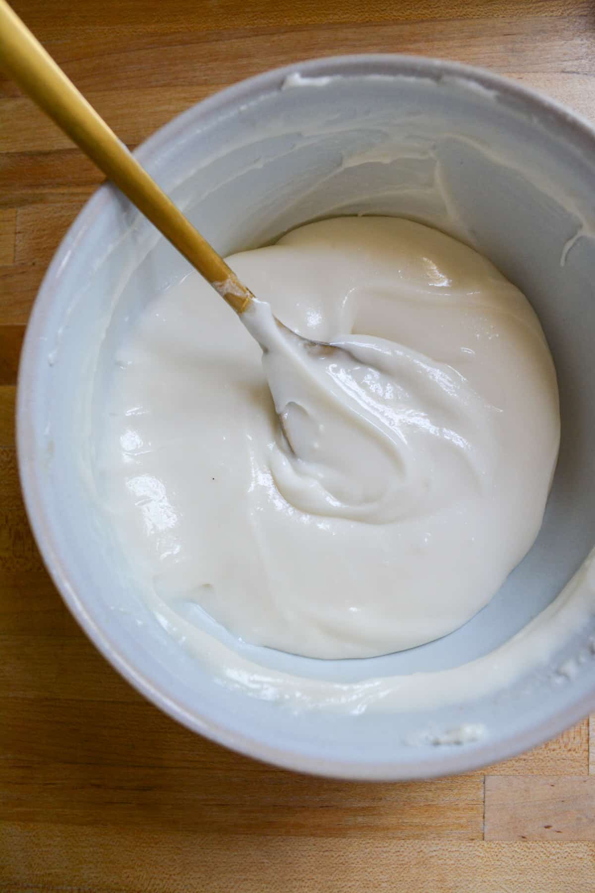 cream cheese frosting in a white bowl