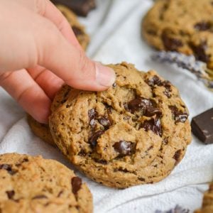 Hand holding a vegan espresso chocolate chip cookie