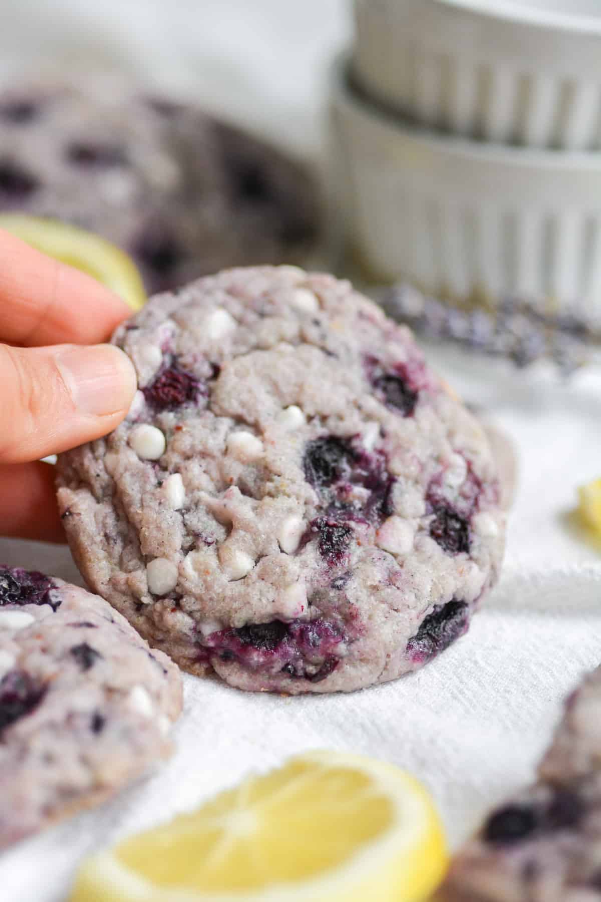Hand holding a vegan lemon blueberry sugar cookie
