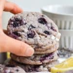 Hand holding a cookie on a stack of cookies