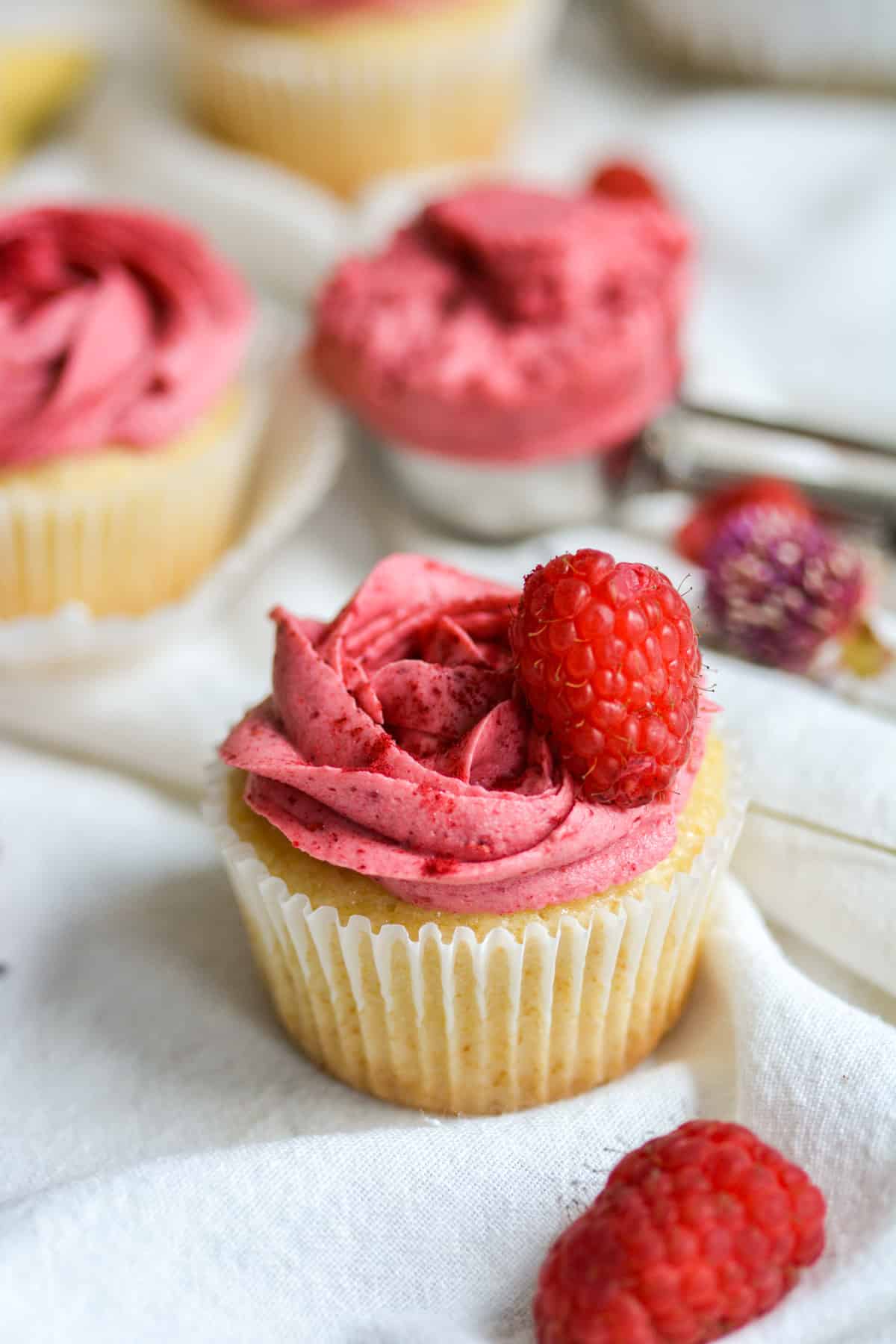 a vegan lemon raspberry cupcake on a white cloth