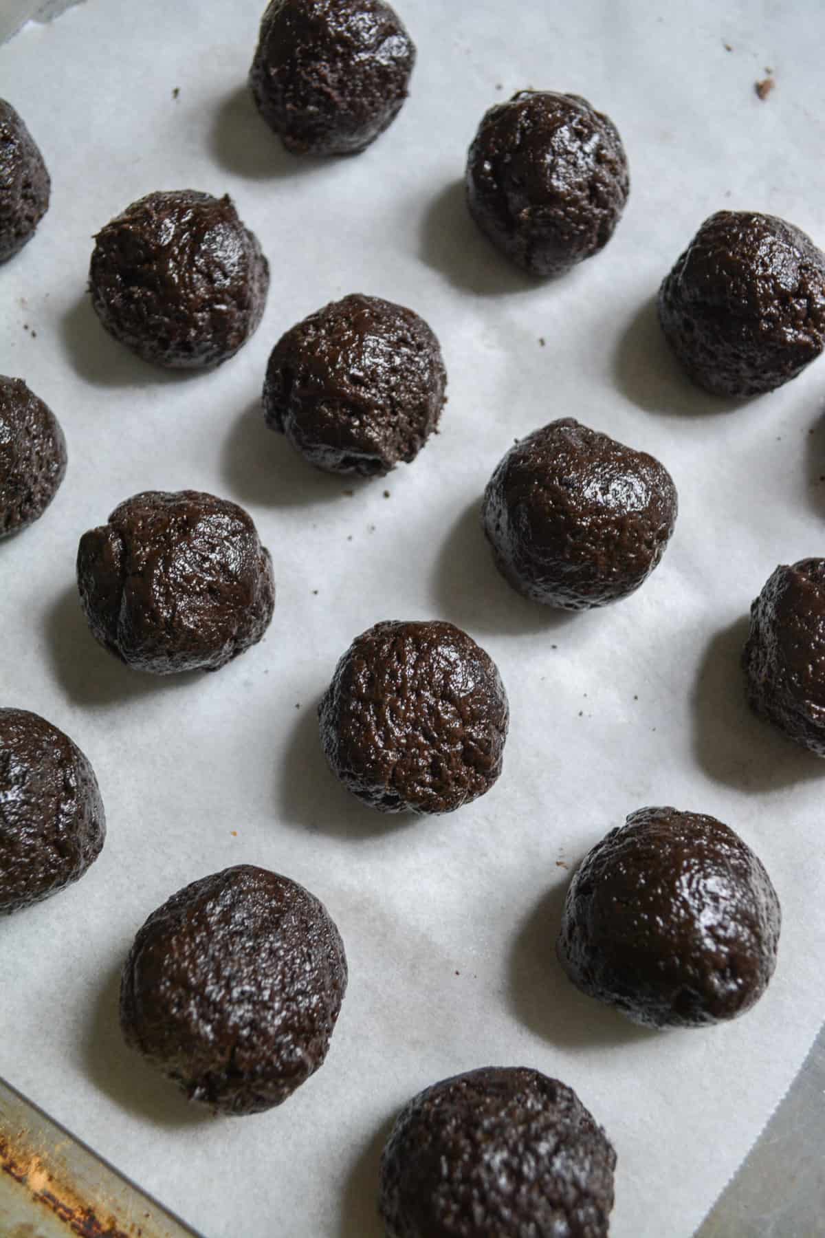 Rolled dairy-free oreo truffles on a baking sheet.