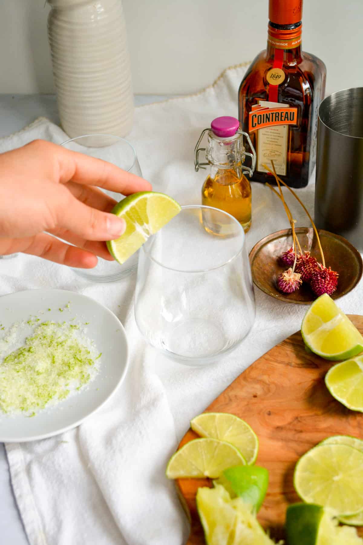 Rubbing the rim of a glass with a lime wedge.