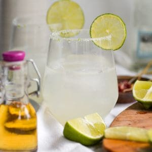 straight-on shot of a sparkling margarita with a lime salt rim.
