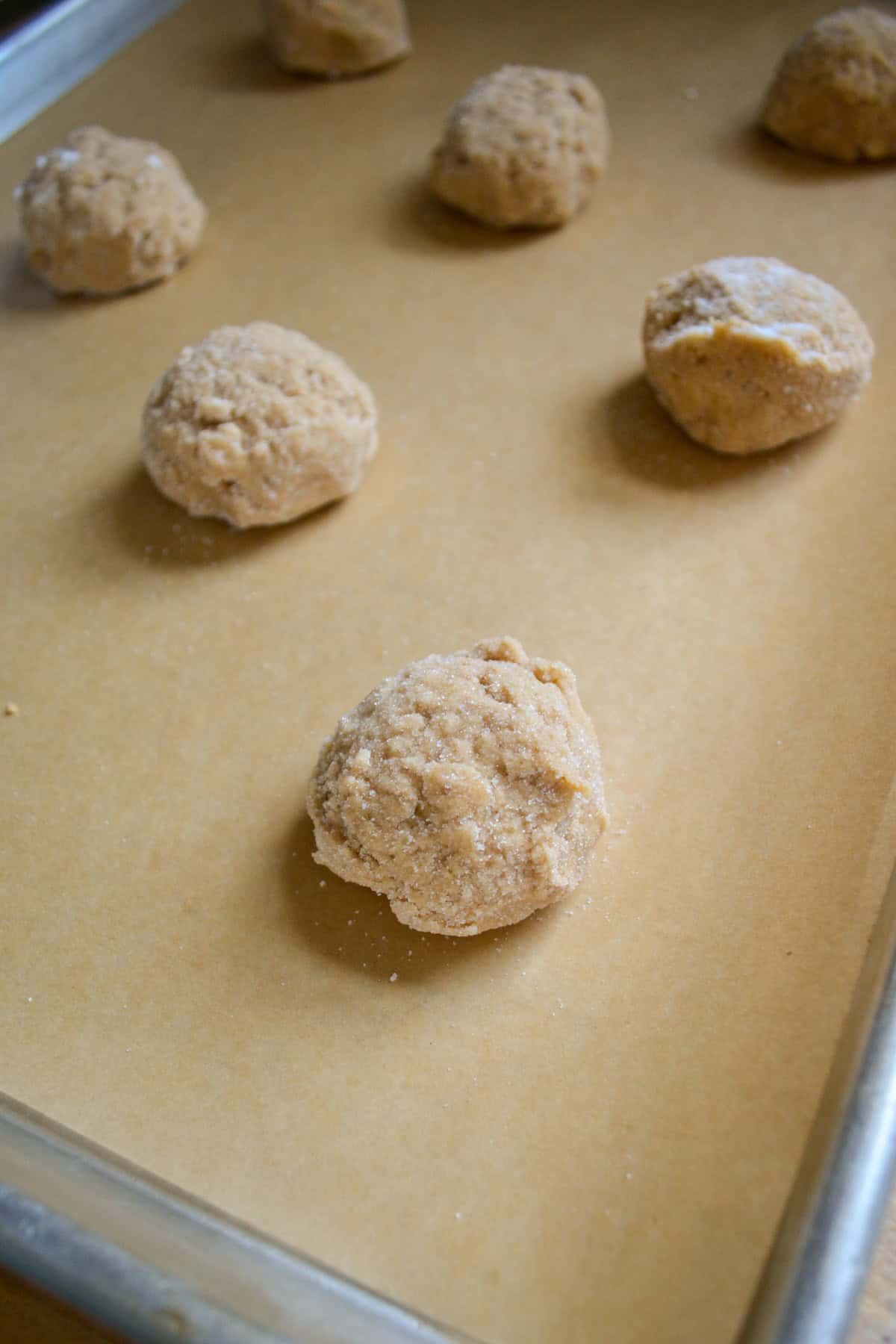 Cookie dough scooped onto a parchment-lined baking sheet.