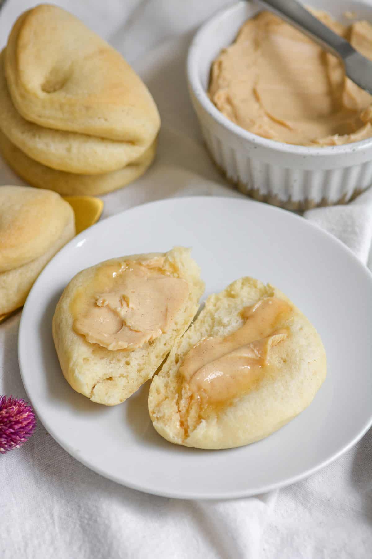 A parker house roll spread with vegan cinnamon honey butter