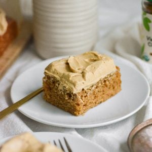 A slice of vegan dirty chai masala cake on a white plate with a gold fork.