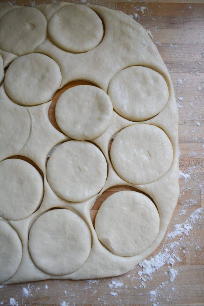 Circles cut out of dough on a wooden surface.