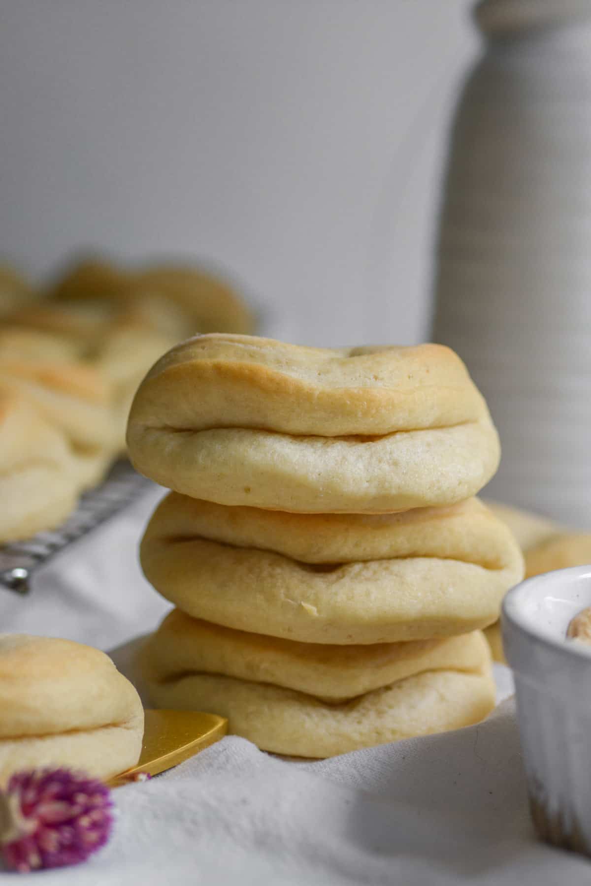 A stack of three Vegan Parker House Dinner Rolls on a white cloth