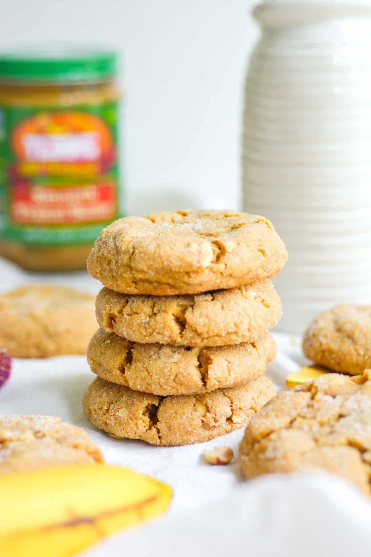 A stack for four vegan peanut butter banana cookies on top of each other on a whit cloth.
