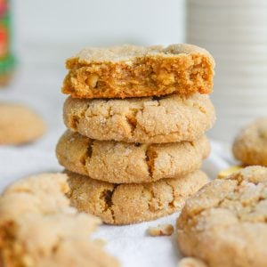 A stack of vegan peanut butter banana cookies with the top cookie broken in half