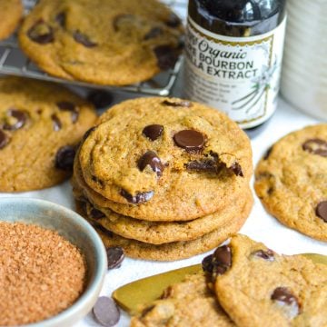 A stack of Vegan Pumpkin Chocolate Chip Cookies on a linen surface.