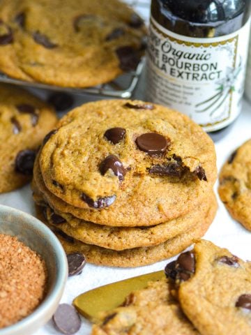 A stack of Vegan Pumpkin Chocolate Chip Cookies on a linen surface.