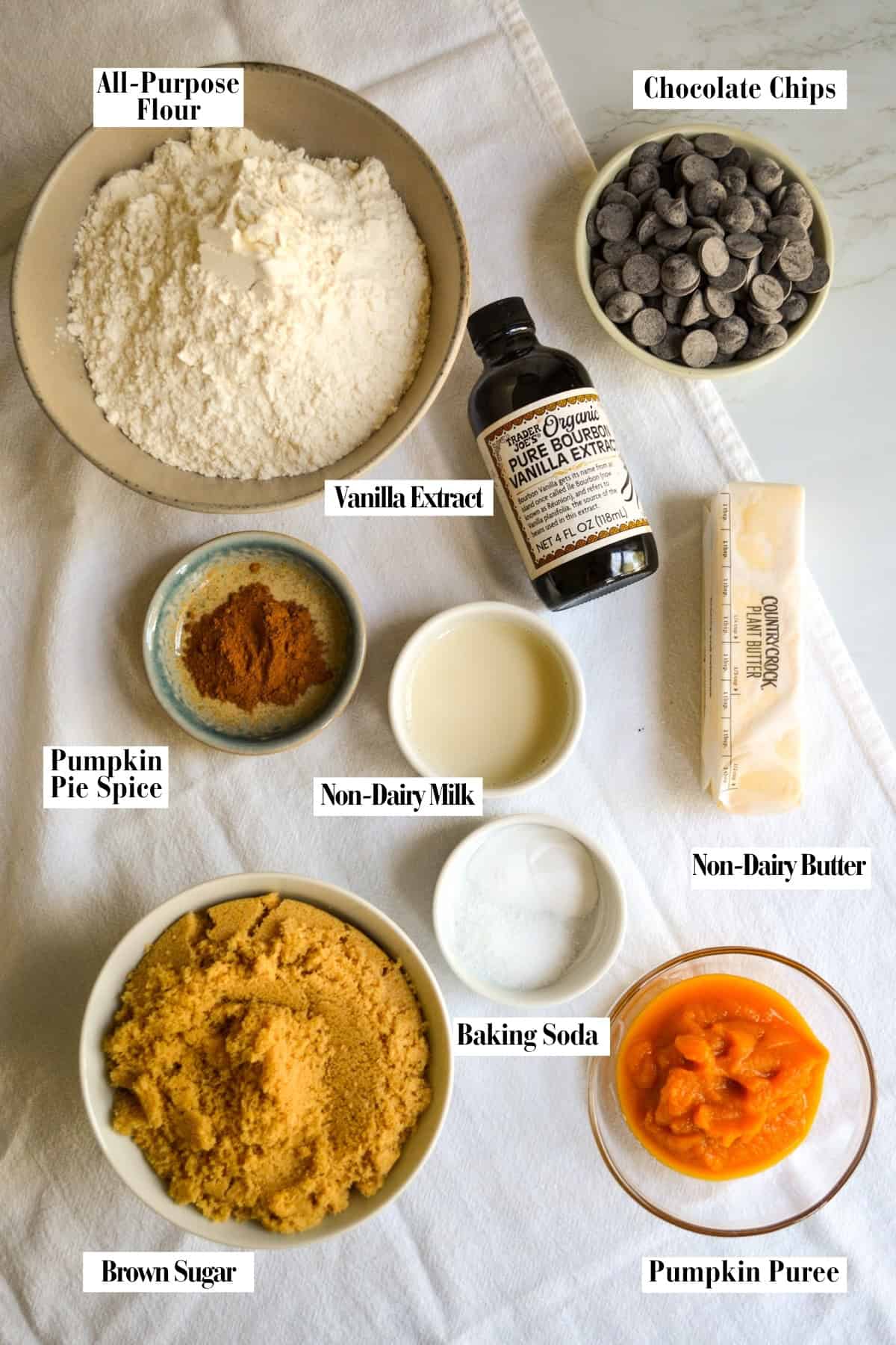 Ingredients for the cookies in small bowls on a linen surface.