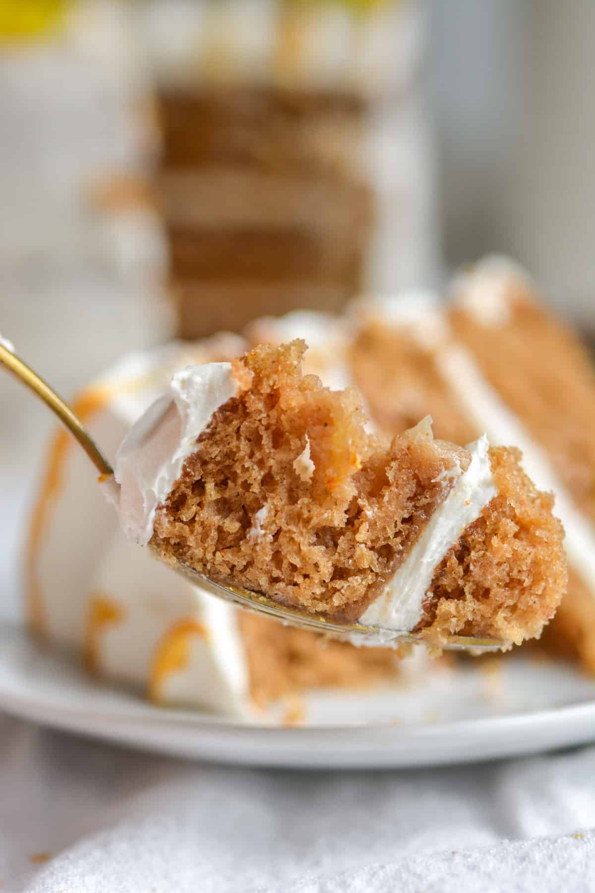 A fork with a bite of vegan apple spice cake on it.