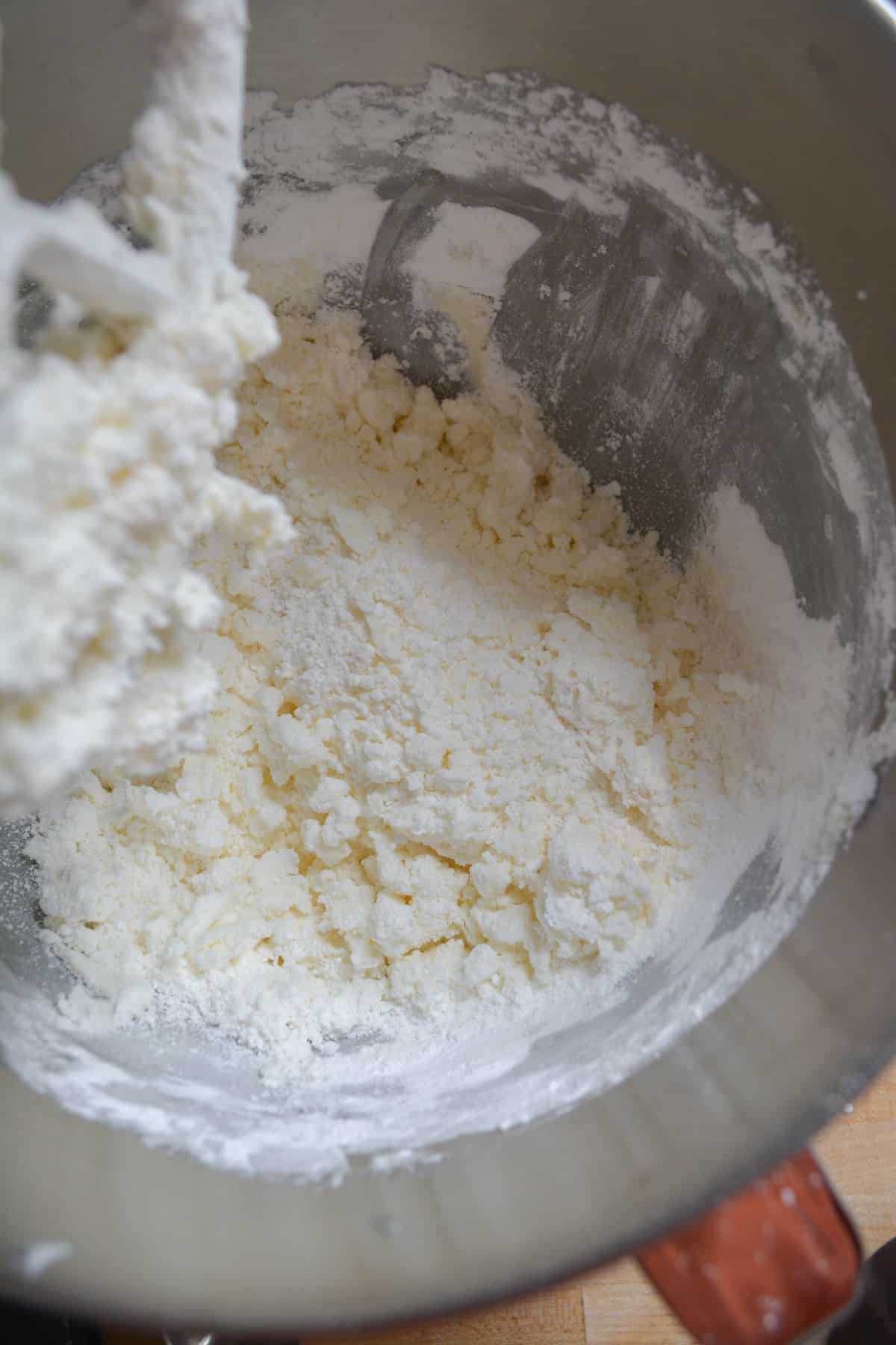 Adding the powdered sugar into a metal bowl.