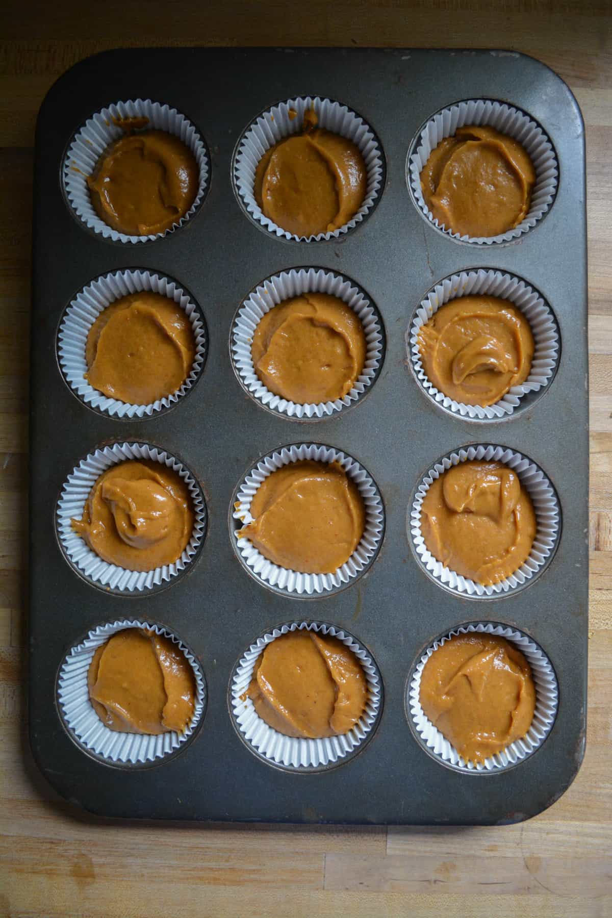 Dairy Free and Eggless Pumpkin Cupcake batter scooped into the cupcake tin.