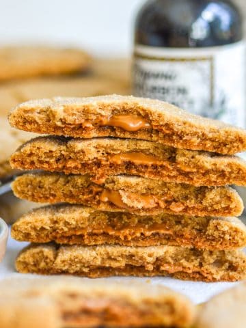 A stack of Vegan Biscoff Stuffed Cookies broken in half to show their molten interior.
