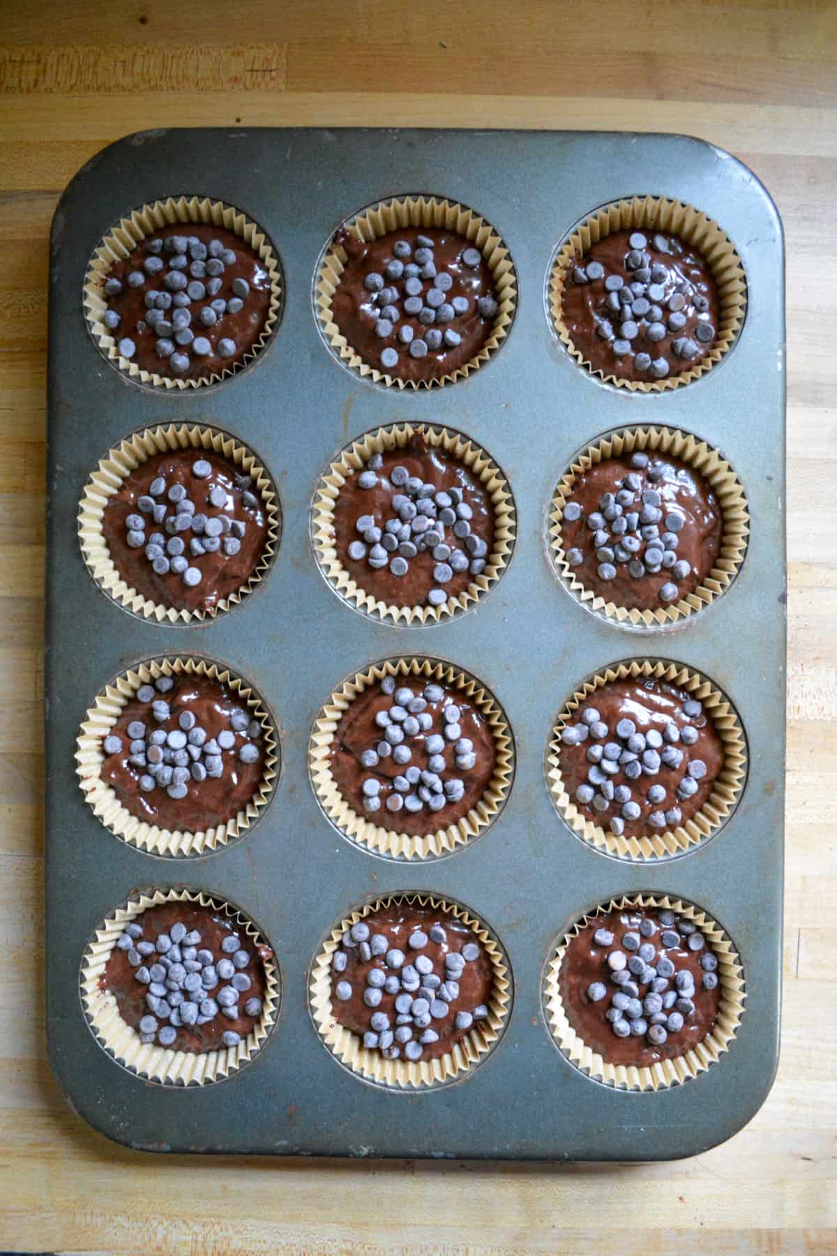 Vegan Double Chocolate Banana Bread Muffin batter scooped into a muffin pan.