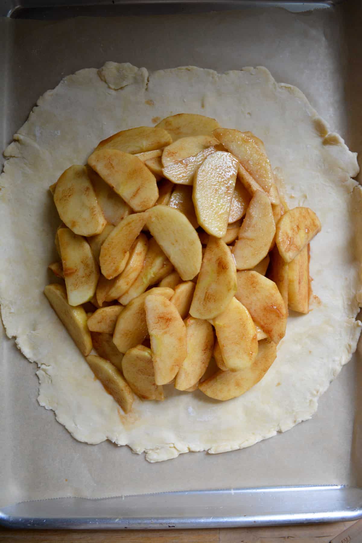 The pie dough topped with the spiced apples.