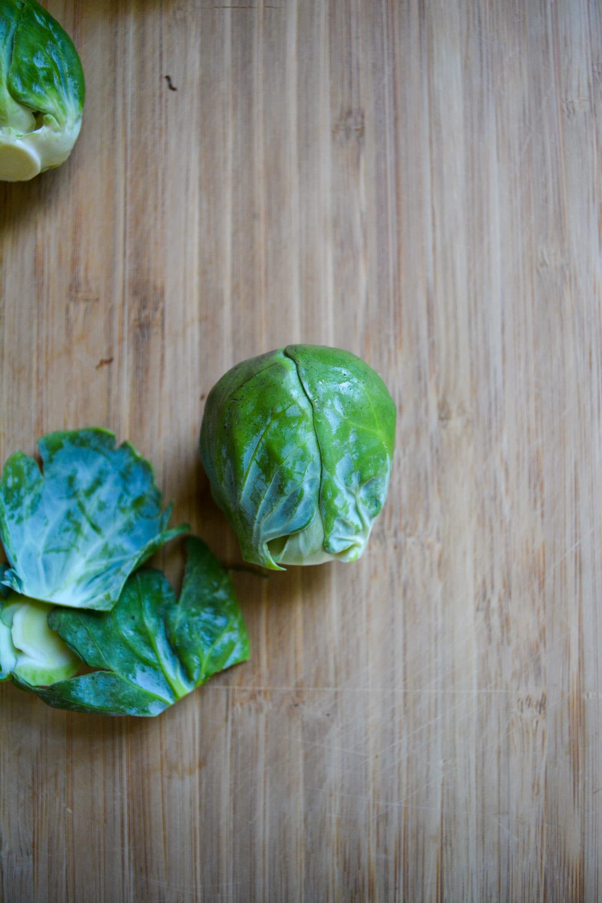 Brussels sprout on a cutting board with the root cut off.