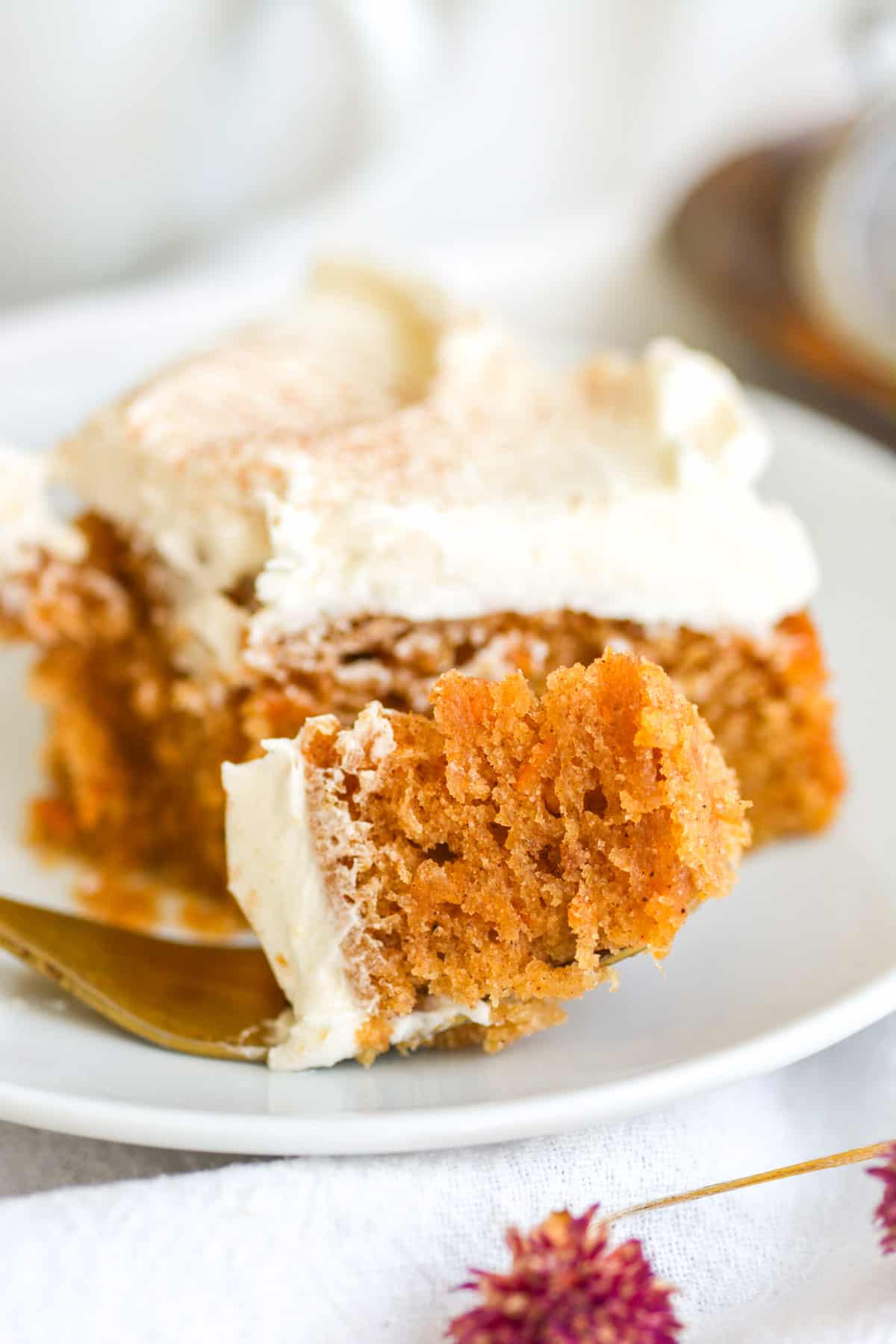 A fork with a bite of Vegan Maple Sweet Potato Cake on it with the remaining cake in the background.