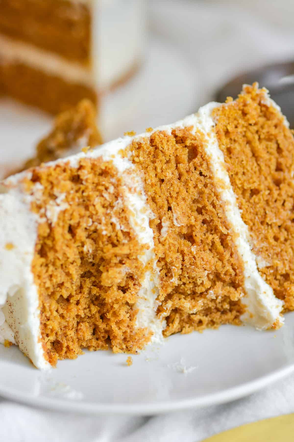 A bite taken out of the vegan and eggless pumpkin spice layer cake.