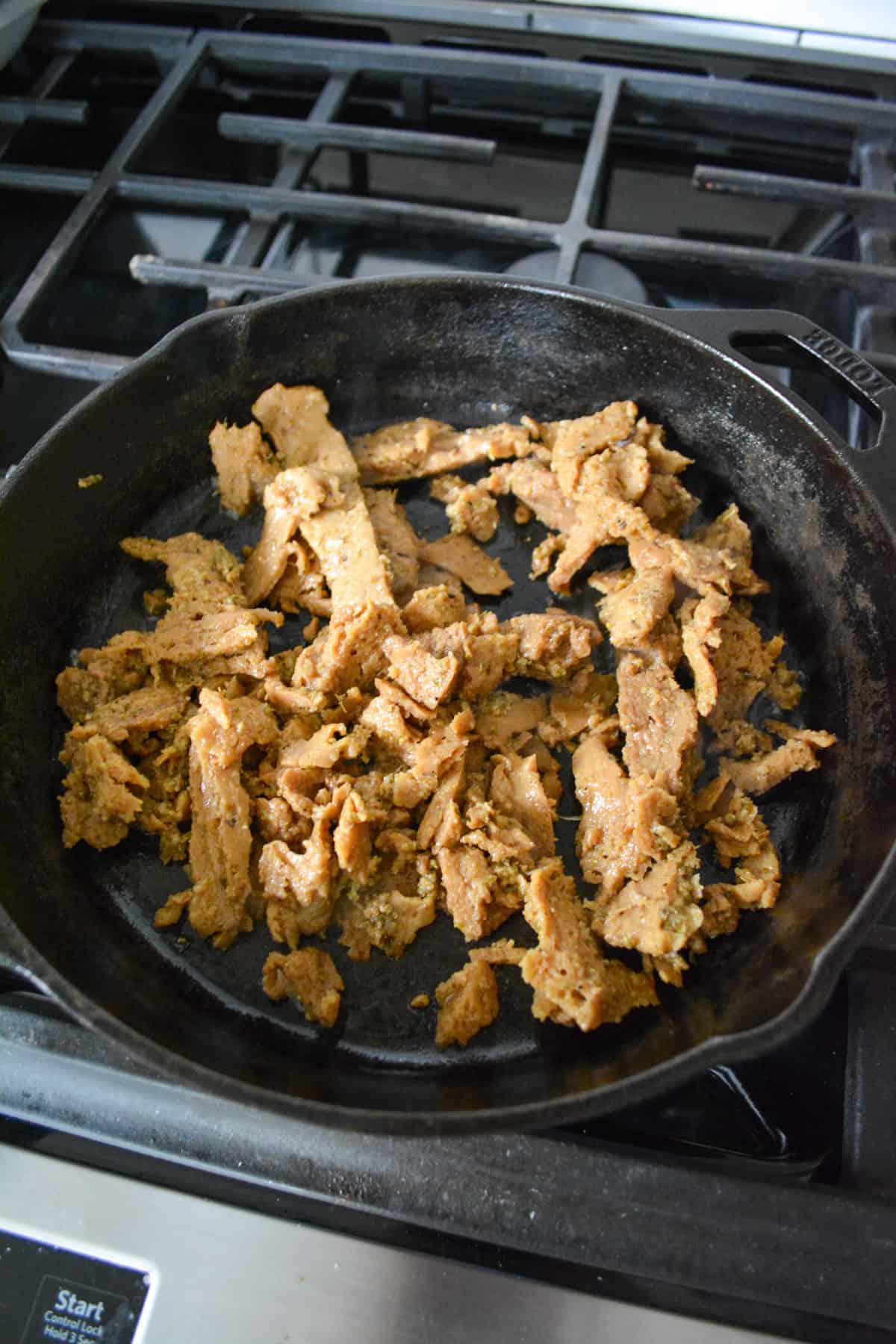 Seitan cooking in a cast iron skillet.